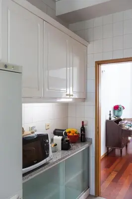 a kitchen with white cabinets and a microwave at Seagull Rooftop Downtown - Light and Views in Porto