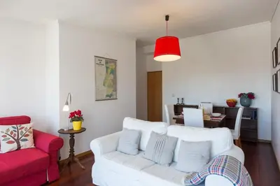 a living room with a white couch and a red chair at Seagull Rooftop Downtown - Light and Views in Porto