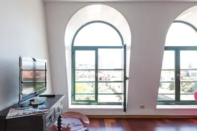 a living room with two windows and a mirror at Seagull Rooftop Downtown - Light and Views in Porto