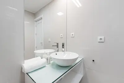 a white bathroom with a sink and a mirror at GuestReady - Fabric Porto Apartment in Porto