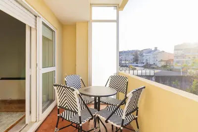 a balcony with chairs and a table and a window at 3BR Joyous Wonder by LovelyStay in Porto
