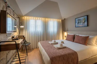 a hotel room with a large bed and a desk at Carpe Diem Porto By Dualgroup in Porto