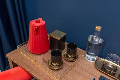 a table with a bottle and cups on it at Hotel Kodawari Flores - by Kodawari Residences in Porto