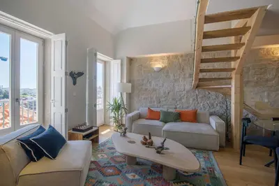 a living room with a couch and a staircase at Portobliss Apartment in Porto