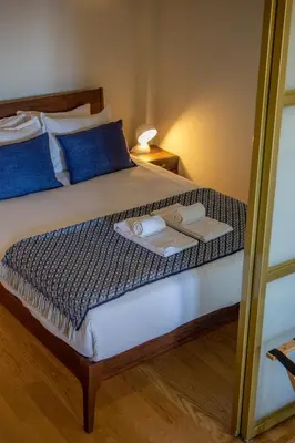 a bed with blue pillows and a tray of food on it at Portobliss Apartment in Porto