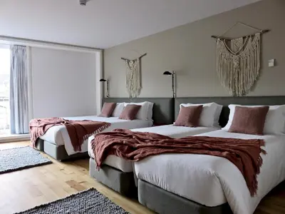 two beds in a hotel room with a large window at Oporto Serviced Apartments - Miragaia II in Porto