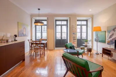 a kitchen and living room with green chairs and a table at Once Upon In Porto Apartments II in Porto