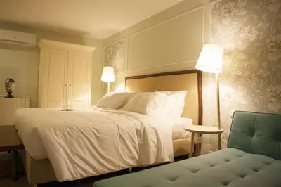 a bedroom with a white bed with two lamps and a couch at In Porto Gallery Guesthouse in Porto