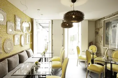 a dining room with yellow chairs and tables at In Porto Gallery Guesthouse in Porto