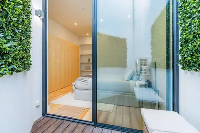 a living room with white walls and wooden floors at Casa da Música Modern Flat in Porto