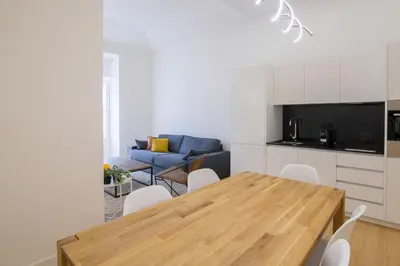 a living room with a table and a blue couch at Aliados Living Apartment in Porto