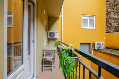 a yellow building with cars parked in front of it at Almada Prime Apartment I in Porto