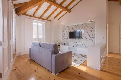 a living room with a couch and a tv at Almada Prime Apartment II in Porto