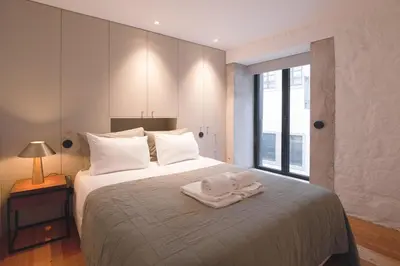 a bedroom with a bed with two towels on it at Andrade Rooftop Duplex in Porto