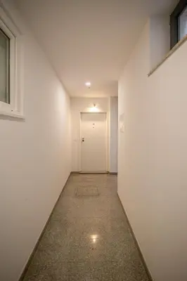 an empty hallway with a white wall and a door at Canto Flores in Porto