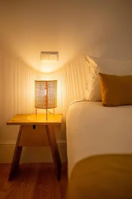 a bed and a table with a lamp on it at Canto Flores in Porto