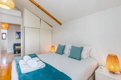 a bedroom with a white bed with towels on it at Catedral da Sé Apartment in Porto