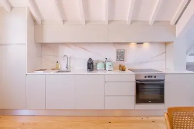 a white kitchen with a sink and a stove at Rua Formosa 99 in Porto