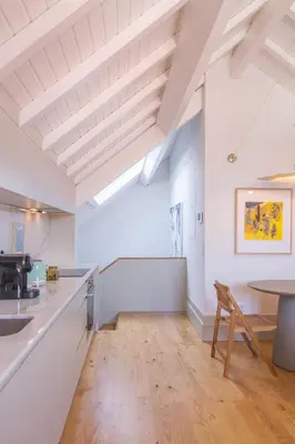 a kitchen with white walls and a wooden floor at Rua Formosa 99 in Porto