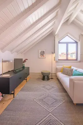 a living room with a white couch and a window at Rua Formosa 99 in Porto