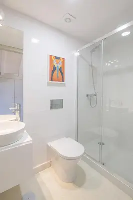 a white bathroom with a toilet and a shower at Rua Formosa 99 in Porto