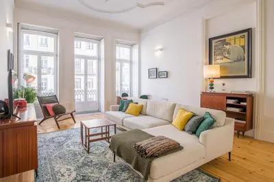 a living room with a white couch and some windows at Mouzinho Hill View in Porto