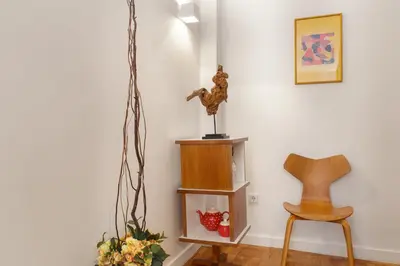 a living room with a chair and a shelf at VIVA Cozy Downtown in Porto