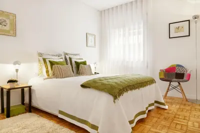 a bedroom with a large white bed with green pillows at VIVA Cozy Downtown in Porto