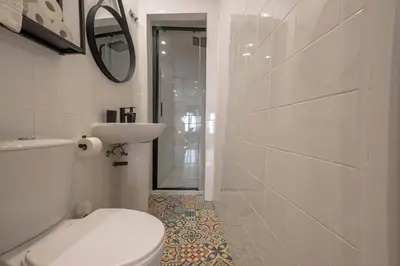 a bathroom with a toilet and a sink and a mirror at River Corticeira II in Porto