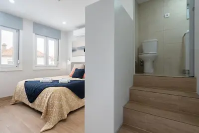 a bedroom with a bed and a toilet at Charming Bright House w/ Garden by HostWise in Porto