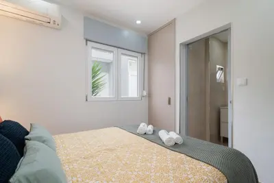 a bedroom with a bed with two towels on it at Charming Bright House w/ Garden by HostWise in Porto