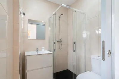 a bathroom with a shower and a toilet and a sink at Charming Bright House w/ Garden by HostWise in Porto