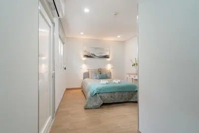 a bedroom with a bed in a white room at Charming Bright House w/ Garden by HostWise in Porto