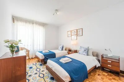 a bedroom with two beds with blue sheets and a table at GuestReady - Eclectic haven in the heart of Porto in Porto