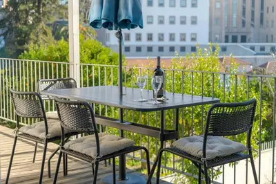 a table and chairs on a balcony with an umbrella at Loveporto Varanda Jardim Centro in Porto