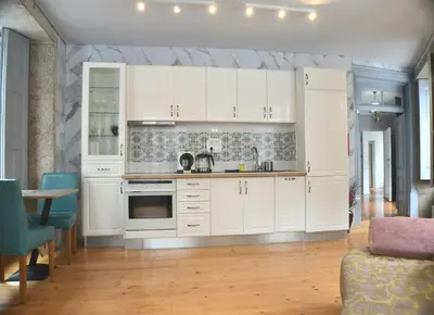 a kitchen with white cabinets and a table and chairs at Ribeira Riverview Panoramic in Porto
