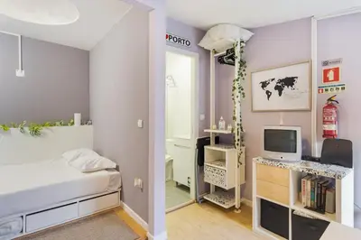 a bedroom with a bed and a desk with a computer at Island House in Porto