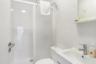 a bathroom with a shower and a toilet and a sink at Island House in Porto