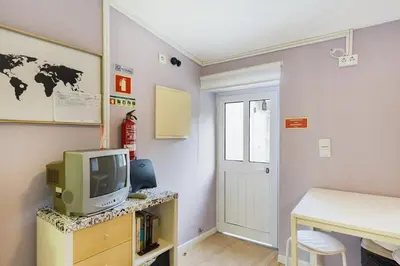 a room with a tv and a desk and a door at Island House in Porto
