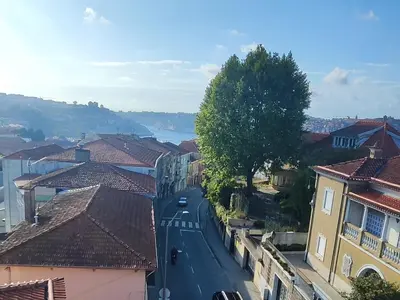 a city street with houses and a river in the background at Gaia Riverview in Vila Nova de Gaia