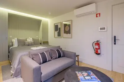 a bedroom with a bed and a couch in front of it at Pleasant Studio Santa Catarina in Porto