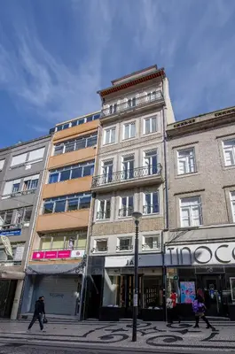 a tall building with people walking in front of it at Pleasant Studio Santa Catarina in Porto