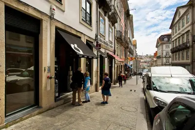 a group of people standing outside of a store on a street at Ribeira Memories 72 in Porto