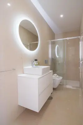 a white bathroom with a sink and a mirror at Topo Flores Apartment in Porto
