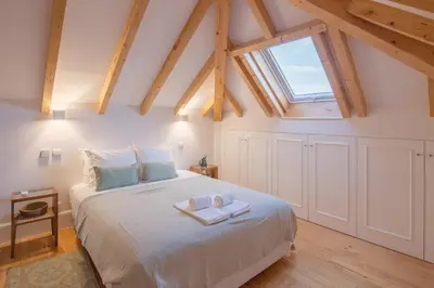 a bedroom with a large white bed with a window at Topo Flores Apartment in Porto
