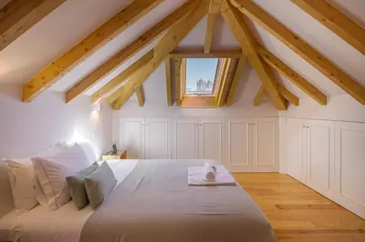 a bedroom with a large white bed with a window at Topo Flores Apartment in Porto