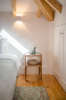 a bedroom with a bed and a table with a vase on it at Topo Flores Apartment in Porto