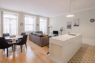 a kitchen and living room with a couch and a table at Virginie Almada Apartment in Porto