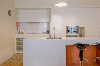 a kitchen with white cabinets and a counter top at Virginie Almada Apartment in Porto