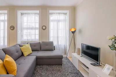 a living room with a couch and a television at Virginie Almada Apartment in Porto